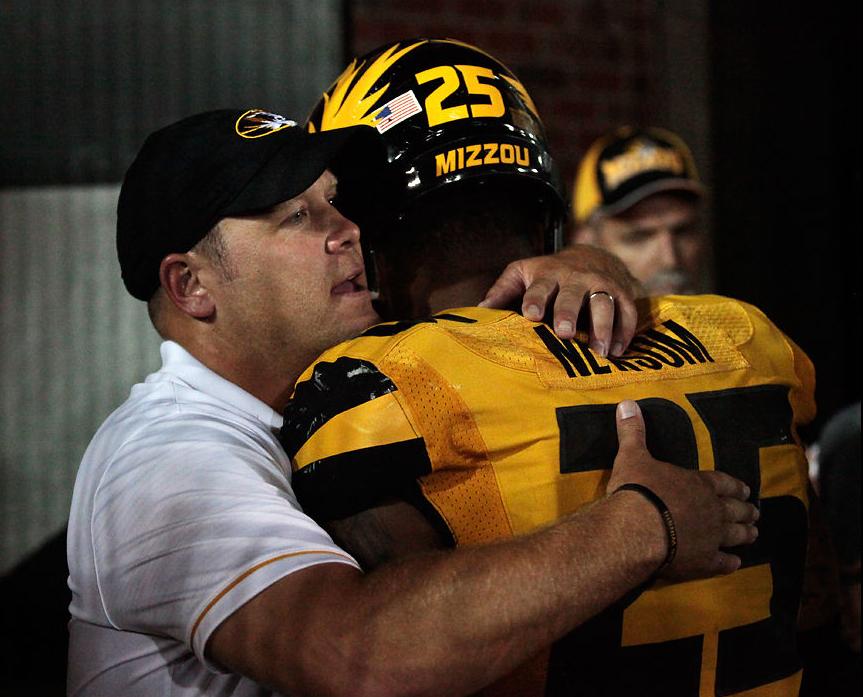 Barry Odom hugs linebacker Donavin Newsom